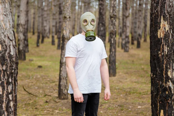身穿白色T恤和防毒面具的男人站在松林里 环境保护 地球节约 污染预防 生物危害概念 — 图库照片