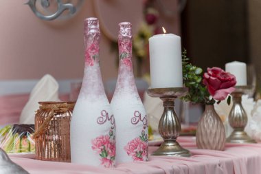 Yeni evlenmiş, organizasyon organizasyonu için süslenmiş pembe düğün başkanlığı. Güzel çiçekler, şampanya şişeleri, mumlar...