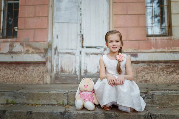 Beyaz Elbiseli Güzel Bir Genç Kız Merdivenlerde Oyuncak Bir Tavşanın — Stok fotoğraf