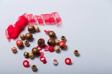 Kırmızı kurdele, boncuk ve dikiş ve nakış için düğme yakın çekim. El işi, bijouterie ve aksesuar yapmak için çok renkli malzemeler. Boşluğu kopyala.