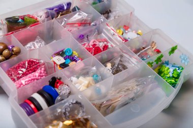 Düğme, dikiş ve nakış işleri için boncuk düzenleyici ya da kap yakın çekim. El işi, bijouterie ve aksesuar yapmak için çok renkli malzemeler..