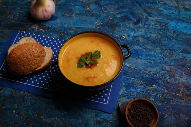 Mercimek ya da bezelye çorbası, ahır ekmeği, sarımsak ve lacivert arka planda baharat. Beslenme, sağlıklı beslenme, organik gıda. Boşluğu kopyala.