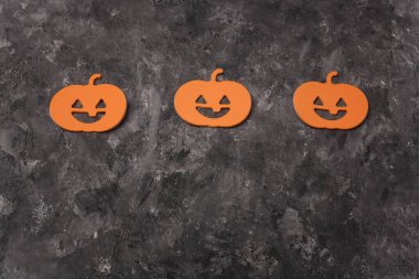 Gri arka planda üç Cadılar Bayramı balkabağı şekilli çıkartma. Cadılar Bayramı çerçeve kartı, kopyalama alanı