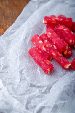 Türk lokumu, beyaz kağıtta fındıklı kırmızı lokum çubukları, ahşap arka plan. Doğu tatlıları, doğu yemekleri. Geleneksel lezzetli tatlı. Uzayı kopyala Üst görünüm