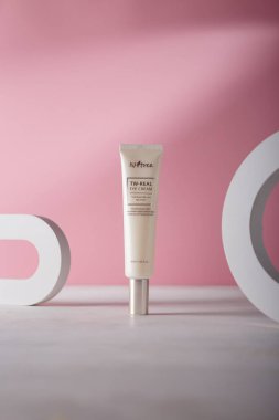 İzmail, Ukrayna. 9 Temmuz 2024. Pembe arka planda, beton dekoratif elementlerle Kore kozmetik tüpü. ISNTREE tonu ve kırışık göz kremi.