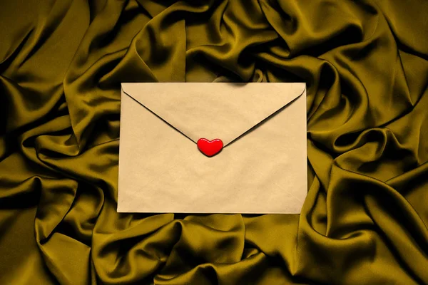 Papírová Obálka Červeným Srdcem Tkanině Zlaté Pozadí — Stock fotografie
