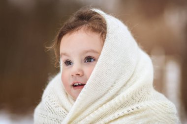 Küçük kız kışın doğada yürür. Kış giysileri