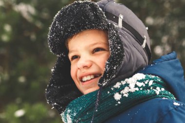 Doğada kış şapkası takmış bir çocuğun portresi. Kış, parkta.