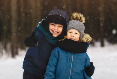 Doğada kışın iki oğlan. Kışlık şapkalı portre