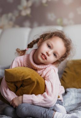 Yatağında yastığı olan düşüncelere dalmış güzel bir kız. Dikey