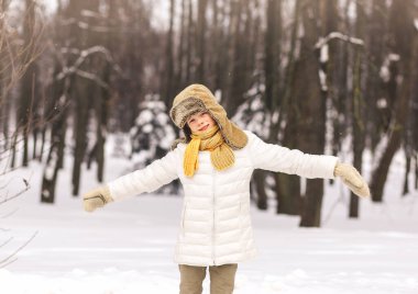 Mutlu çocuk güneşli bir günde kışın parkta oynar.