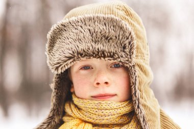 Pofuduk kış şapkalı çilli çocuk.