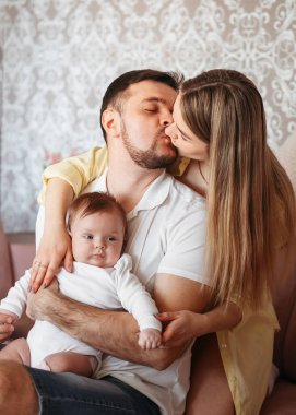 Genç ve güzel anne babalar birbirlerine kızak çektiler ve yeni doğmuş bir kız evlat tuttular.