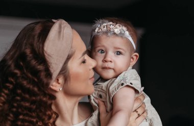 Güzel genç anne kızına bakıyor.