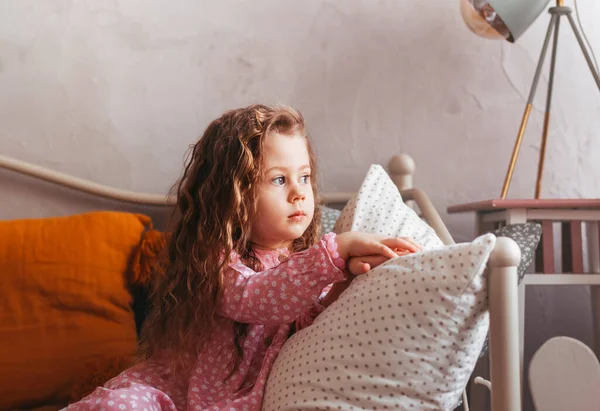 Uma Menina Triste Senta Uma Cama Quarto Olha Pela Janela — Fotografia de Stock