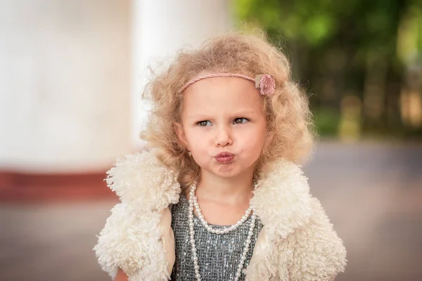 Klein Mooi Meisje Met Krullend Haar Kronkelt Gezichten — Stockfoto