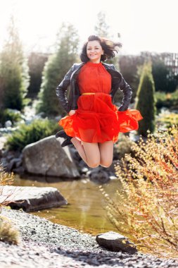 Genç ve mutlu bir kadın uzun bir elbiseyle doğada eğleniyor. Olumlu duygular genç bayan..