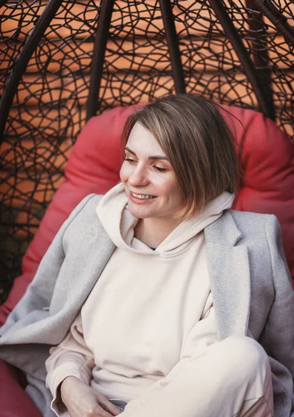 Genç Komik Kadın Dışarıda Örülmüş Bir Sandalyede Vakit Geçiriyor — Stok fotoğraf