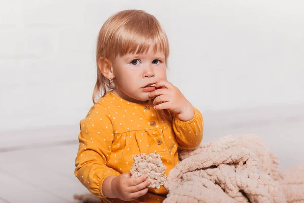 Mała Zabawna Dziewczynka Siedzi Trzyma Bochenek Płatków Ręku — Zdjęcie stockowe