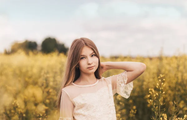 Kolza Çiçeği Arka Planında Uzun Saçlı Güzel Bir Genç Kızın — Stok fotoğraf