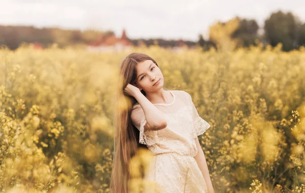 Kolza Çiçeği Arka Planında Uzun Saçlı Güzel Bir Genç Kızın — Stok fotoğraf
