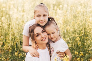 Mutlu genç anne, yazın tecavüz meydanında kızlarına sarılır. Ailenin mutluluğu.