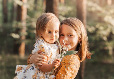 İki tatlı kız kardeş yazın parkta oynuyorlar. Aile zamanı..