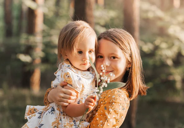İki tatlı kız kardeş yazın parkta oynuyorlar. Aile zamanı..