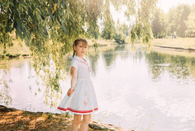 Yazın nehir kıyısında tatlı küçük bir kız.