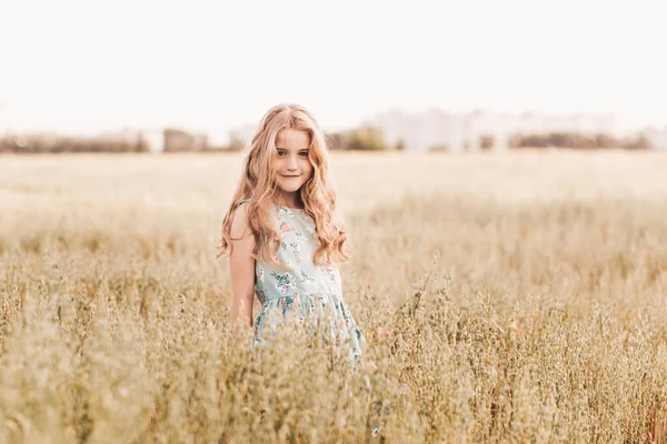美丽的金发小女孩走在麦田里 — 图库照片