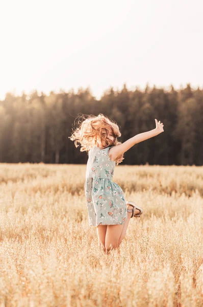 幸せな女の子は晴れた日に夏に小麦畑を駆け抜けています 夏休みだ 幸せな子供時代 肯定的な感情とエネルギー — ストック写真