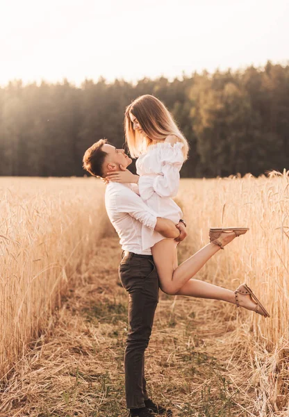 Genç bir çift yazın doğada şefkatle sarılır. Aşıklar