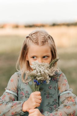 Yazın güneşli gününün tadını çıkaran, duygularını ifade eden, yaz gününde eğlenen, mutlu çocuk yürüyüşü yapan güzel bir kız.