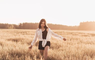 Genç kız yazın doğada yalnız yürür. Siyah saçlı liseli kız dinleniyor.