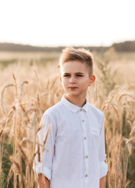 Yazın beyaz gömlekli, beyaz pantolonlu, sarışın, yakışıklı bir çocuk. Mutlu bir çocukluk. Pozitif duygular