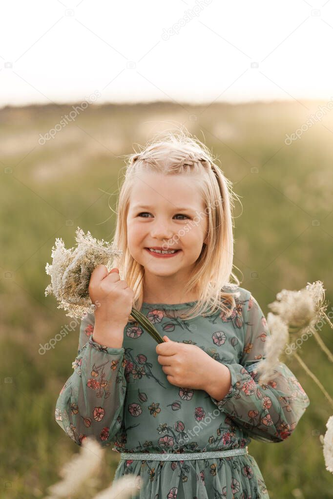 Positive charming little girl enjoying summer sunny day, expression emotions, having fun, happy child walking in summer day