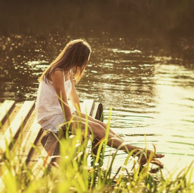 Nehir kıyısında oturan genç kız