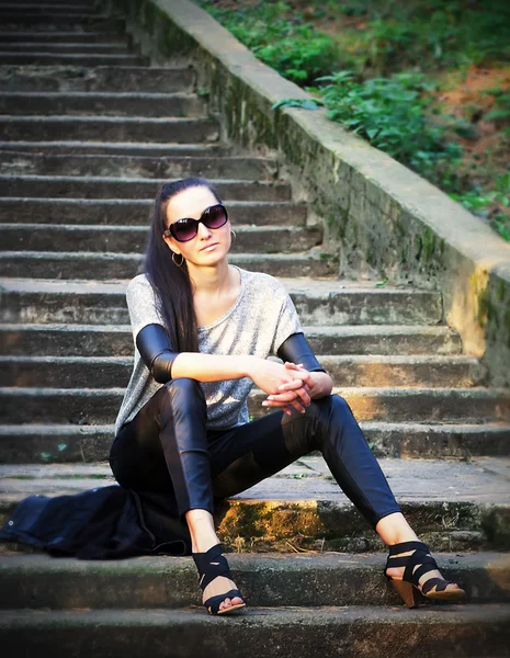 Junges Mädchen mit Sonnenbrille sitzt auf der Treppe — Stockfoto