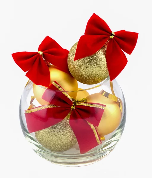 Christmas golden balls and red bow in a glass vase — Stock Photo, Image