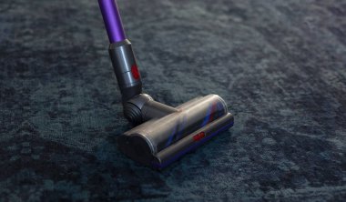 Evdeki bir odadaki halının üzerindeki elektrikli süpürge, ev temizlik sahnesi, düzenli çevre, günlük ev işleri, temizlik, evde bakım..