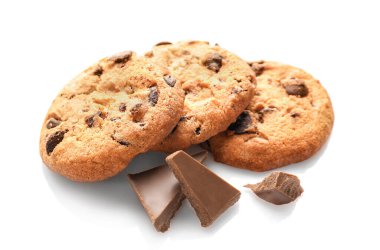 Çikolata parçalı kurabiyeler ve beyaz arka planda izole edilmiş çikolata parçaları..