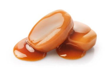 Karamel şekerler ve karamel sosu beyaz arkaplanda izole edilmiş..