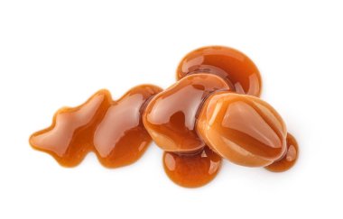 Karamel şekerler ve beyaz arka planda izole edilmiş karamel sosu. Üst görünüm.