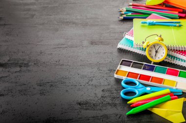 Siyah arka planda bir grup okul malzemesi. Uzayı kopyala Okul konseptine dönelim..