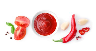 Beyaz arka planda izole edilmiş küçük bir kasede acı biber sosu. Üst görünüm.