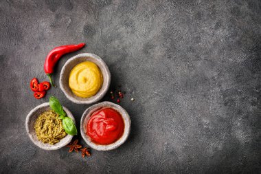 Siyah arka planda küçük kaselerde çeşitli soslar. Üst Manzara. Boşluğu kopyala.