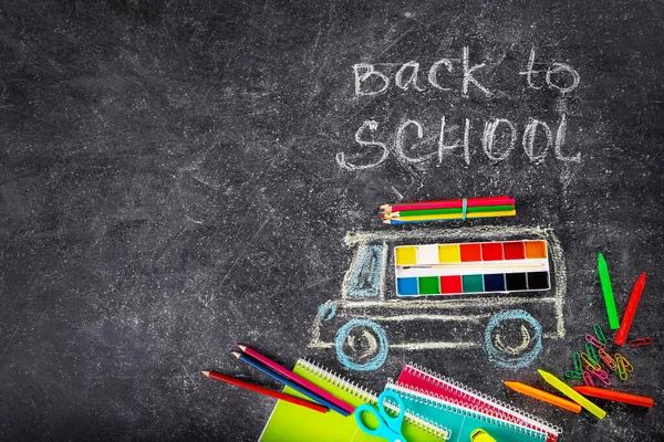 School supplies and school bus painted by chalk on blackboard background. Top view. Copy space. Back to school concept.