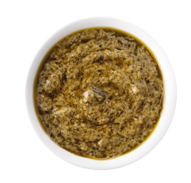 Beyaz arka planda izole edilmiş küçük bir kasede pesto sosu. Üst görünüm.