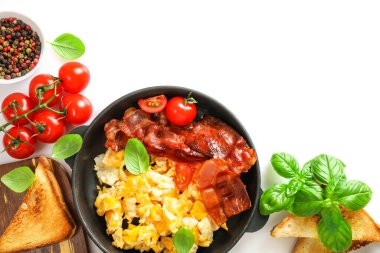 Beyaz arka planda çırpılmış yumurta ve kızarmış pastırmalı Amerikan kahvaltısı. Üst görünüm.