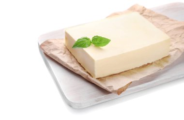 Tahta kesme tahtasındaki taze tereyağı bloğu beyaz arkaplanda izole edildi.